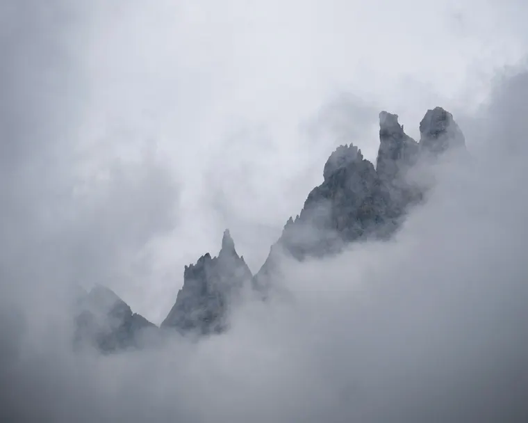 Grey rock spires rising through drifting mist