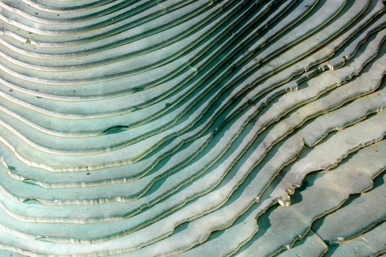 A pale, rhythmic pattern of concentric ripples in shallow water