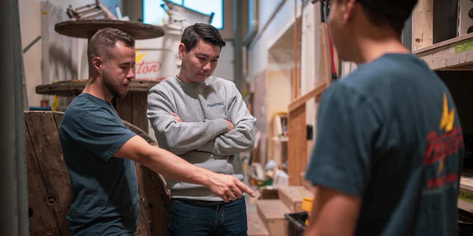 Perry, Abstract Digital's founder, working through a job with two Dayton Power electricians in their shop